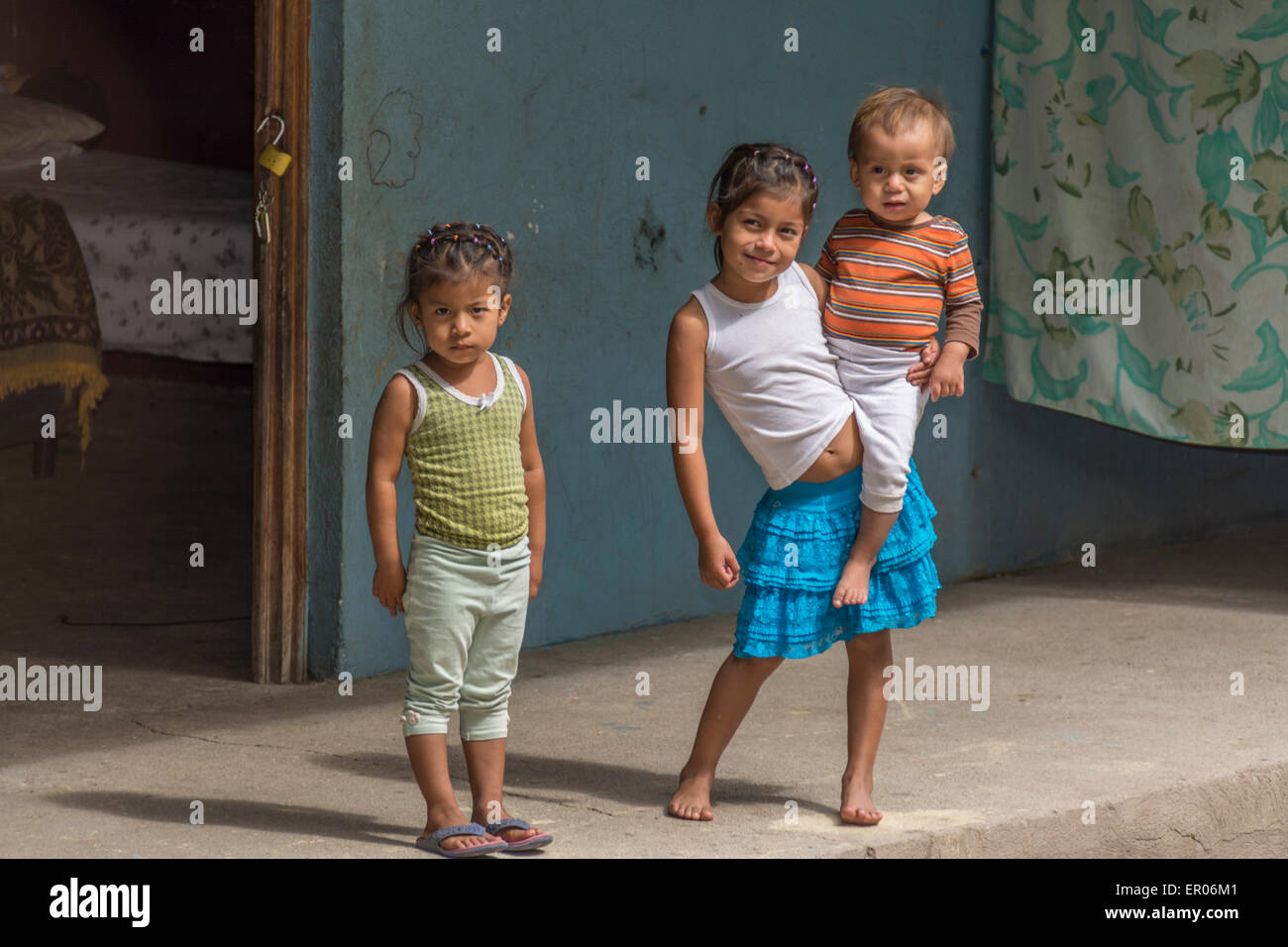 Les enfants debout sur le porche avant d'une maison au Guatemala Banque D'Images