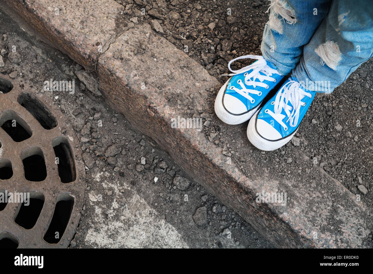 Adolescent pieds de jeans et chaussures bleu se tenir sur le bord de rue. Photo avec mise au point sélective et peu profondes 6 Banque D'Images