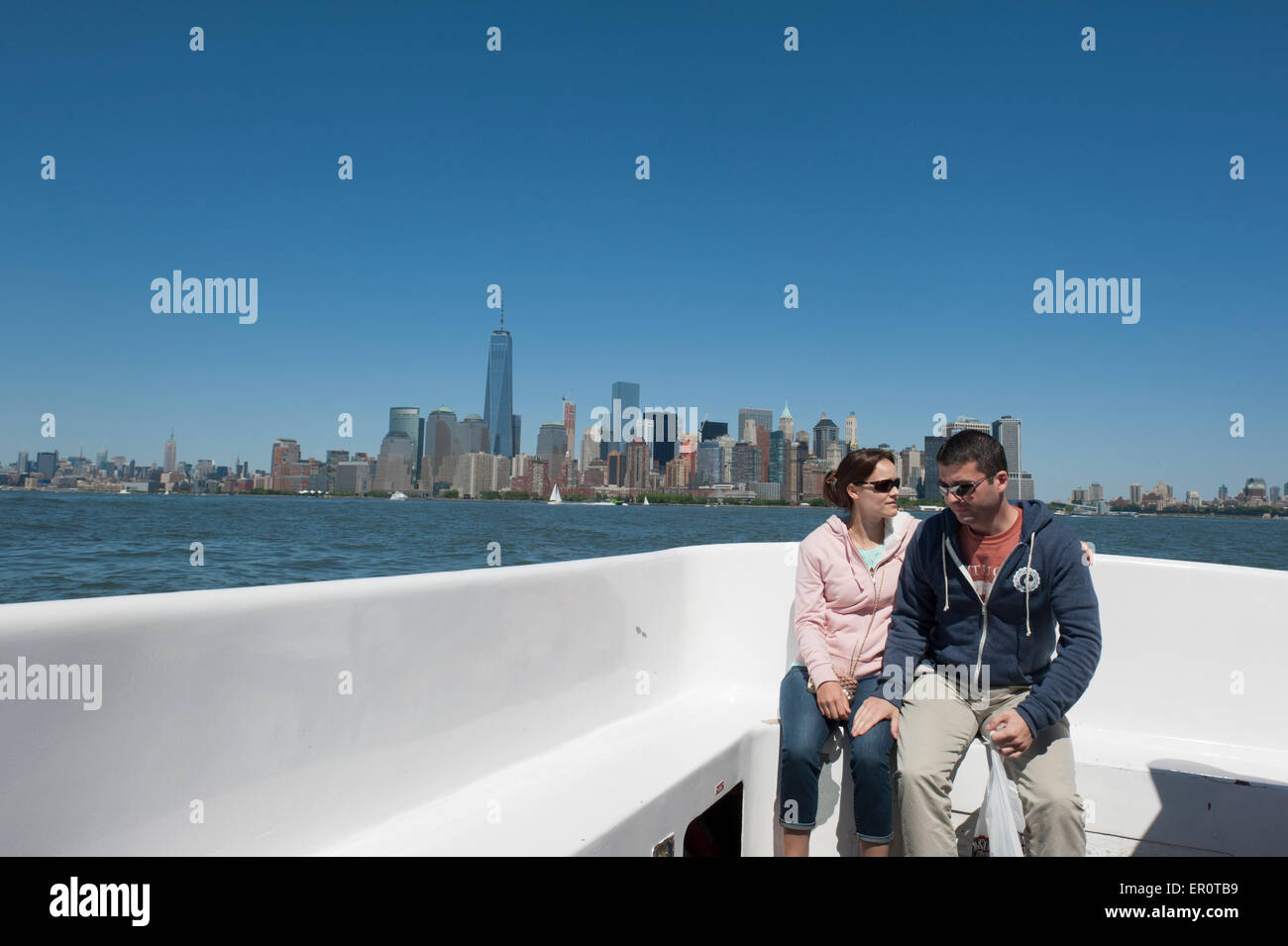 Un couple à bord d'un bateau sur la rivière Hudson à Manhattan dans l'arrière-plan. Banque D'Images