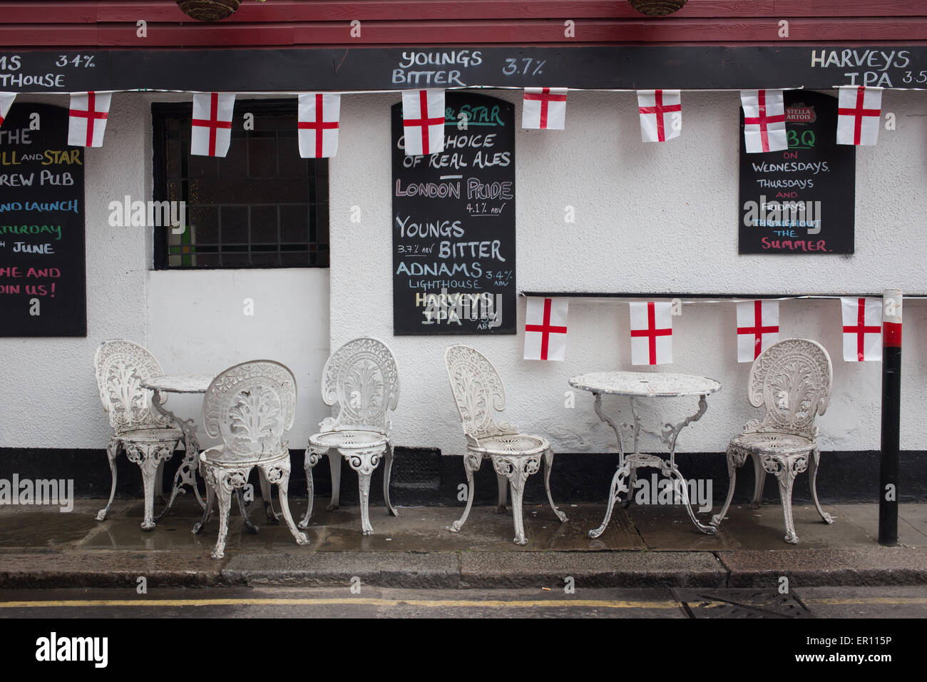 Chaises et tables en métal, et l'Angleterre les drapeaux sur l'extérieur de l'affichage et encore pub Star, Aldgate, pour St George's Day célébrations. Banque D'Images