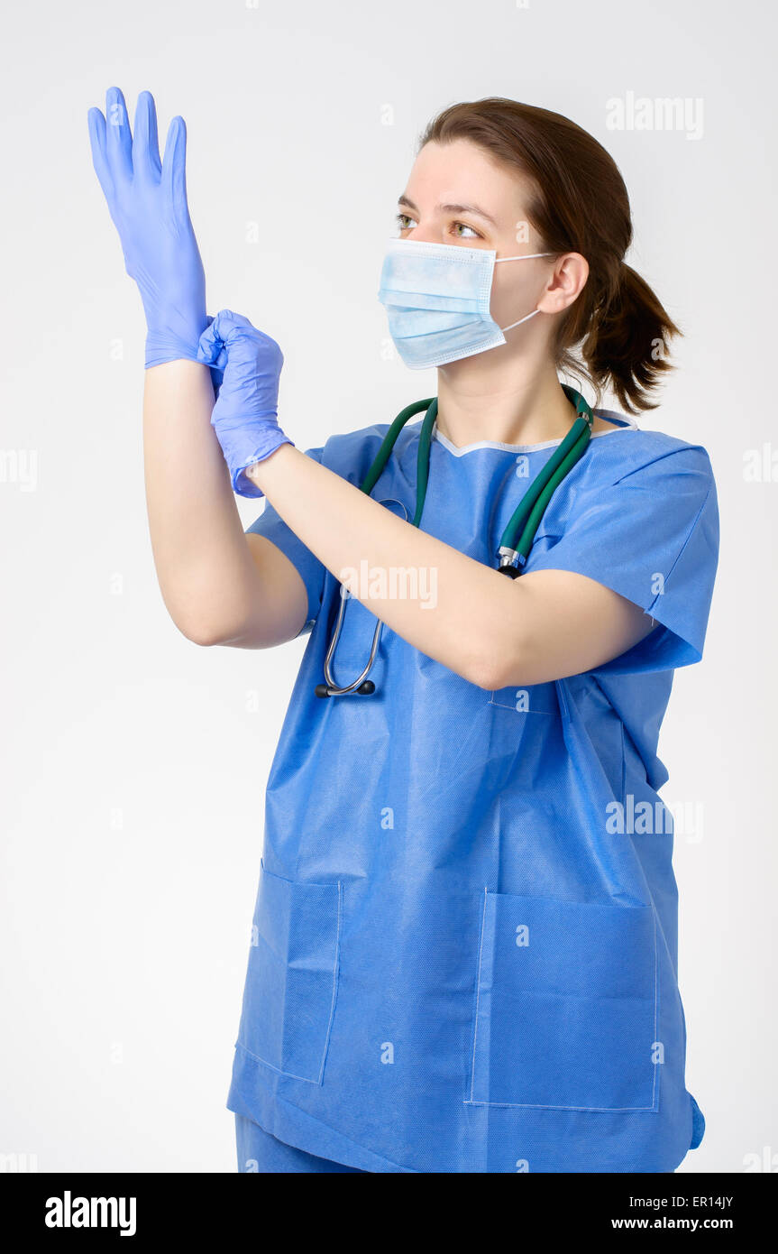 Femme médecin mettre sur bleu gants chirurgicaux Photo Stock - Alamy
