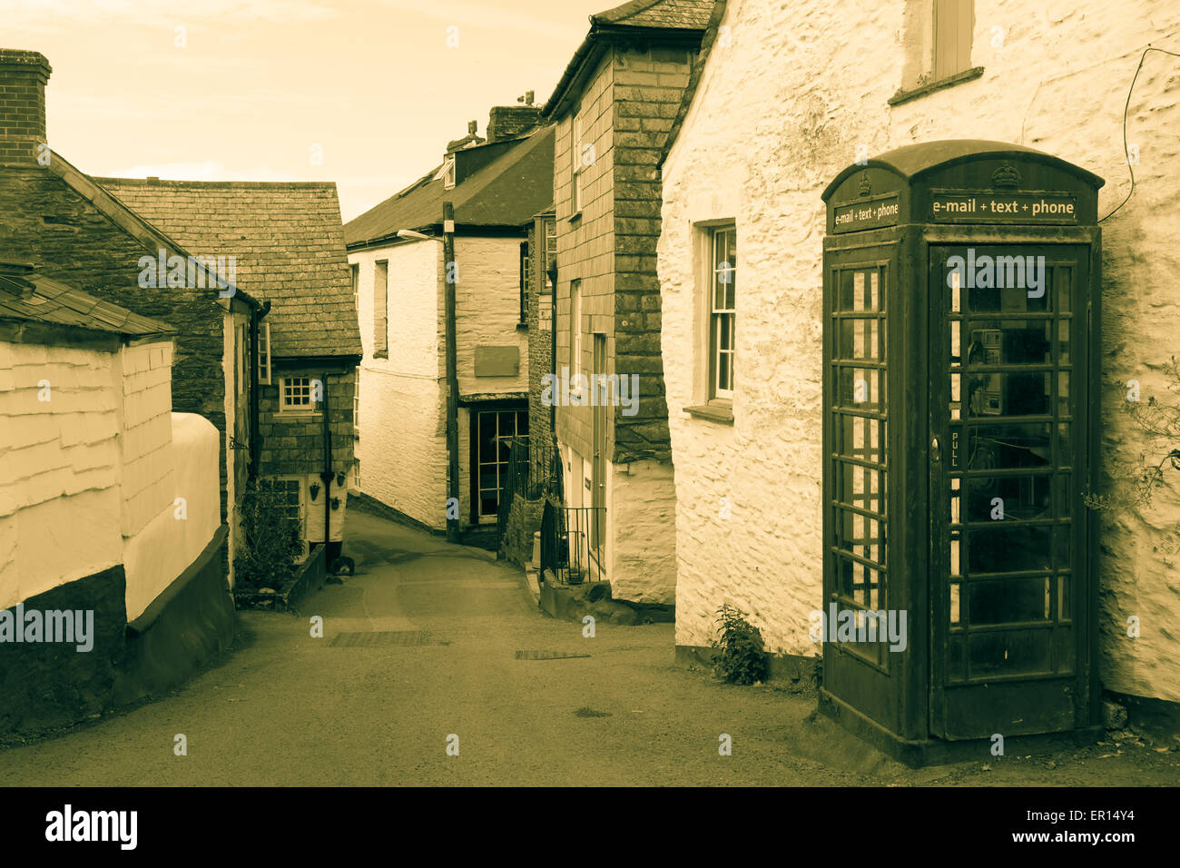 Ruelle à Port Isaac, Cornouailles britannique à l'ancienne cabine téléphonique avec des signes de communication modernes pour convenir à effet ancien Banque D'Images