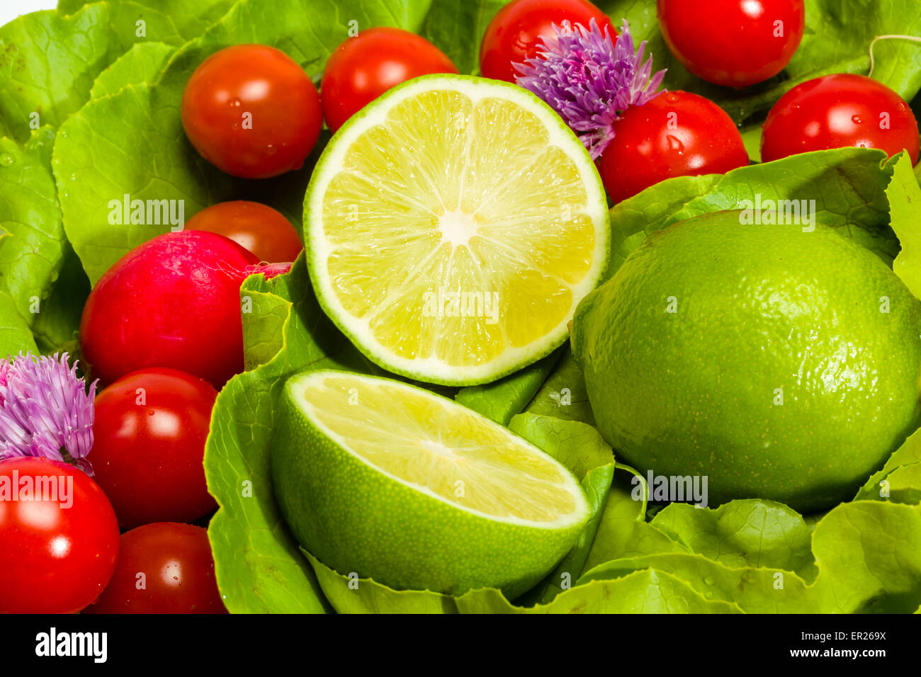 Laitue, radis, ciboulette, citron vert et tomates cerises Banque D'Images