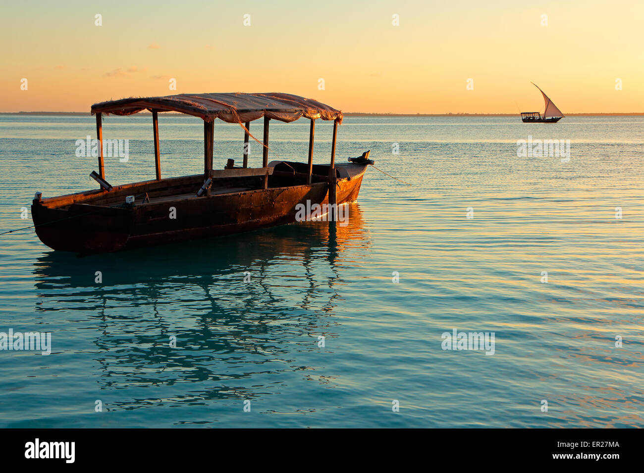 Bateau en bois sur l'eau au coucher du soleil, l'île de Zanzibar Banque D'Images