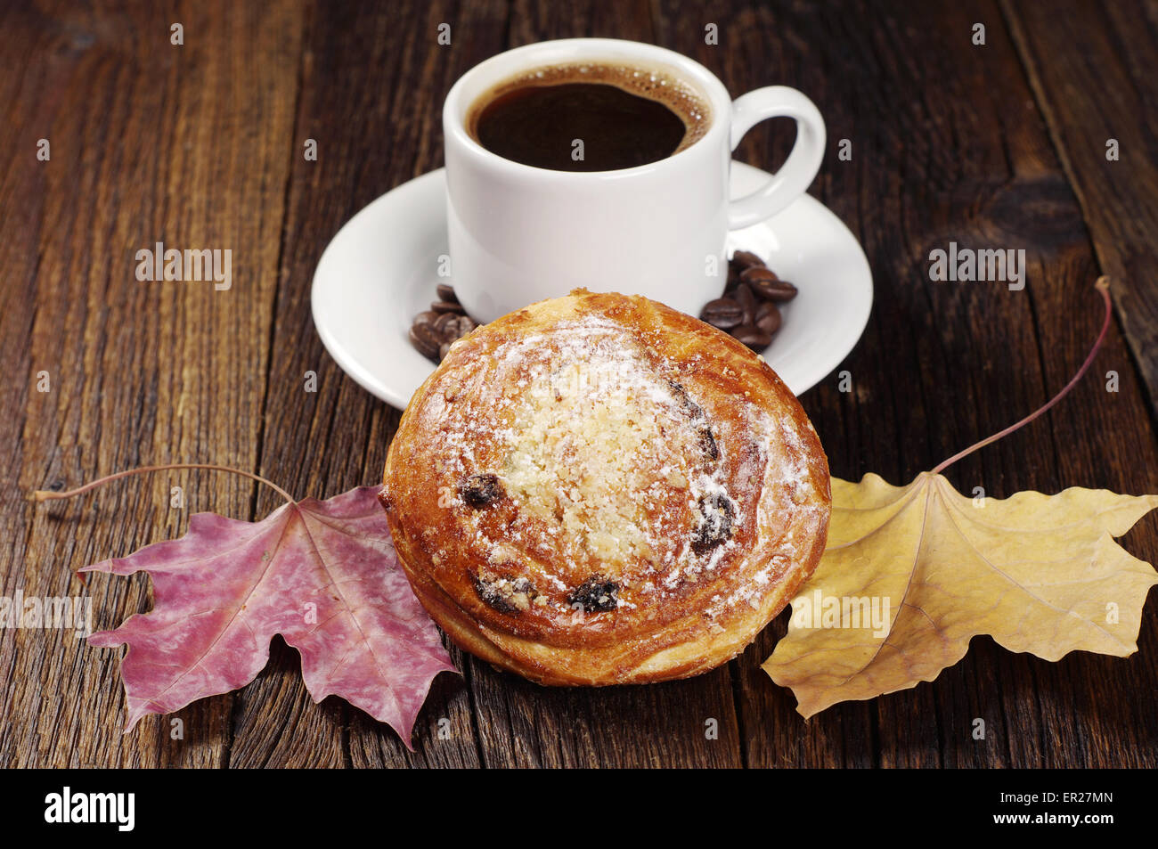 Tasse de café et de petits pains aux raisins sur table en bois vintage. Thème de l'automne Banque D'Images