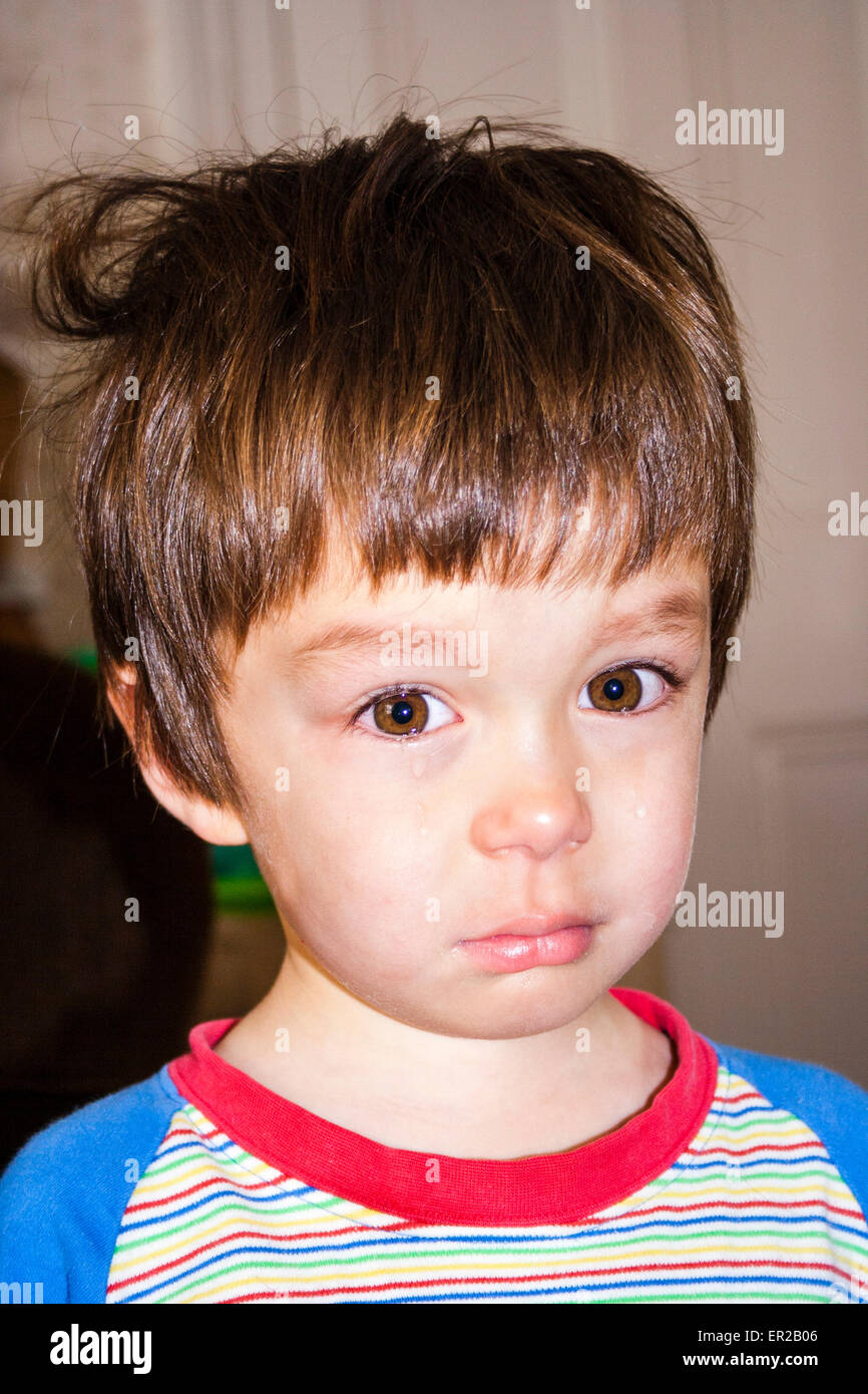 Gros plan de la tête et de l'épaule de jeune enfant, garçon, 3-4 ans, contrarié et pleurant avec des larmes roulantes des joues. Race mixte, caucasien-asiatique. Banque D'Images