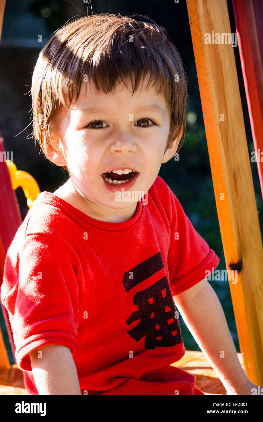 Gros plan d'un enfant, d'un garçon de 3-5 ans, portant un t-shirt rouge à  l'extérieur, au soleil, avec la bouche ouverte, appelant et regardant le  spectateur Photo Stock - Alamy