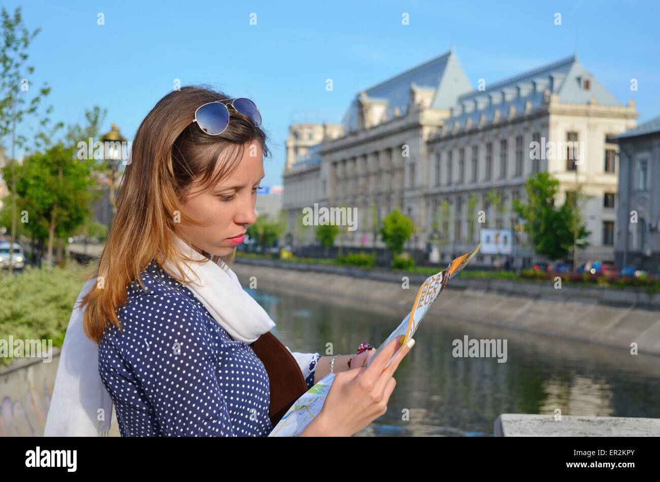 Jeune fille lisant une carte à proximité d'une rivière à Bucarest Banque D'Images
