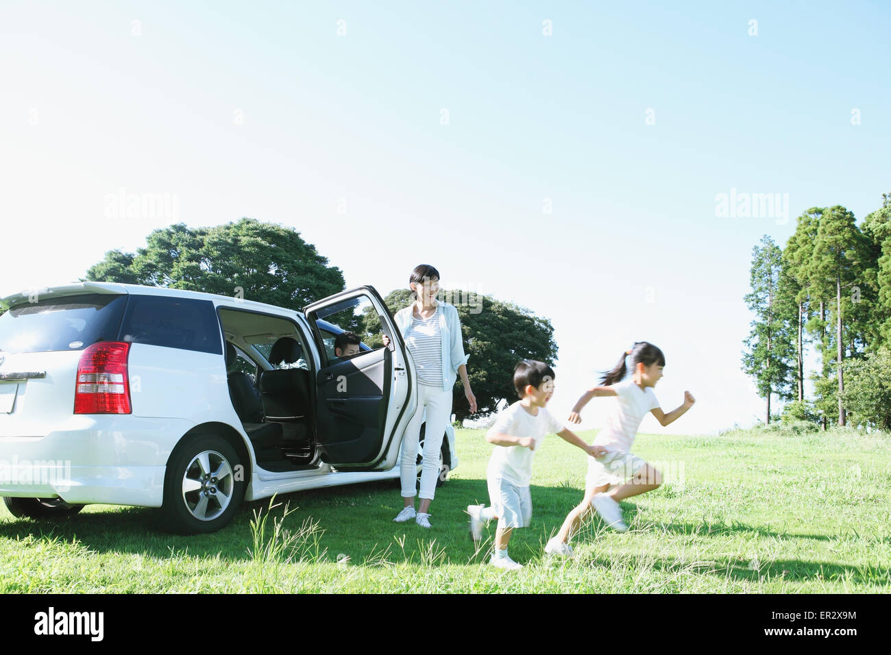 Heureux famille japonaise avec voiture dans un parc de la ville Banque D'Images