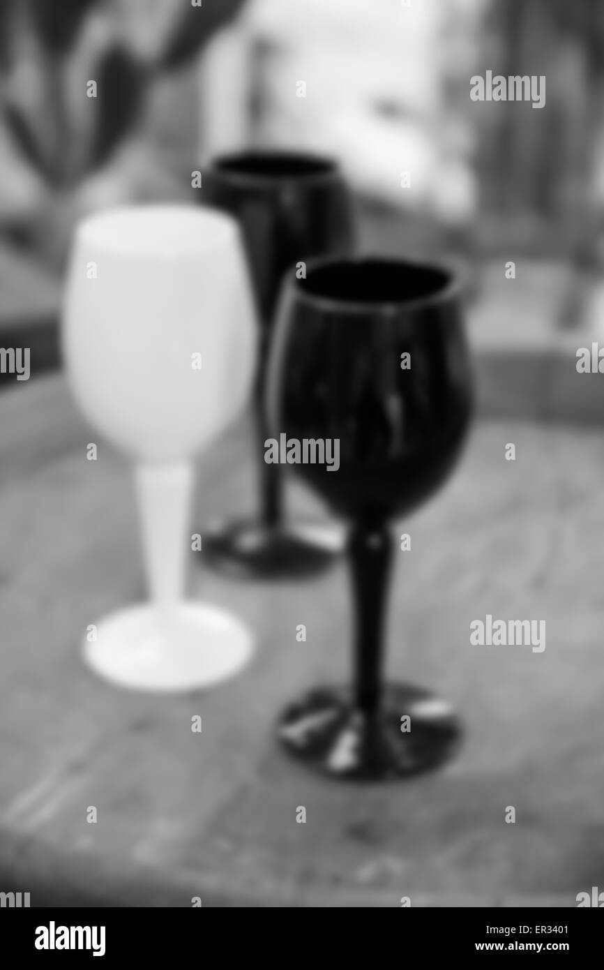 Flou artistique flou de l'image noir et blanc en verre de vin sur fond de bureau en bois Banque D'Images