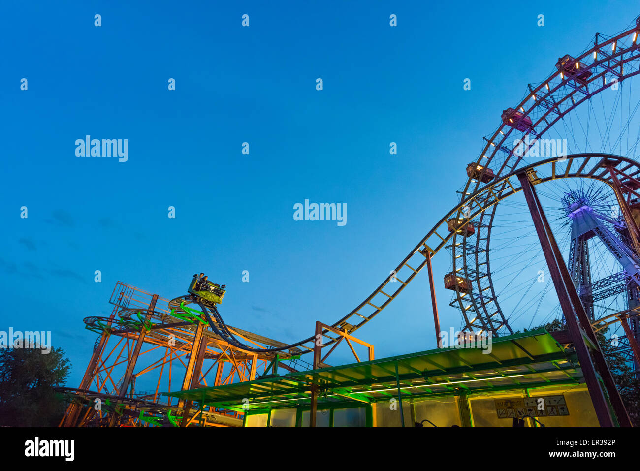 Promenade en montagnes russes, vue la nuit d'un jeune couple en train de profiter d'une promenade en montagnes russes dans le parc d'attractions Prater, Vienne, Vienne, Autriche Banque D'Images