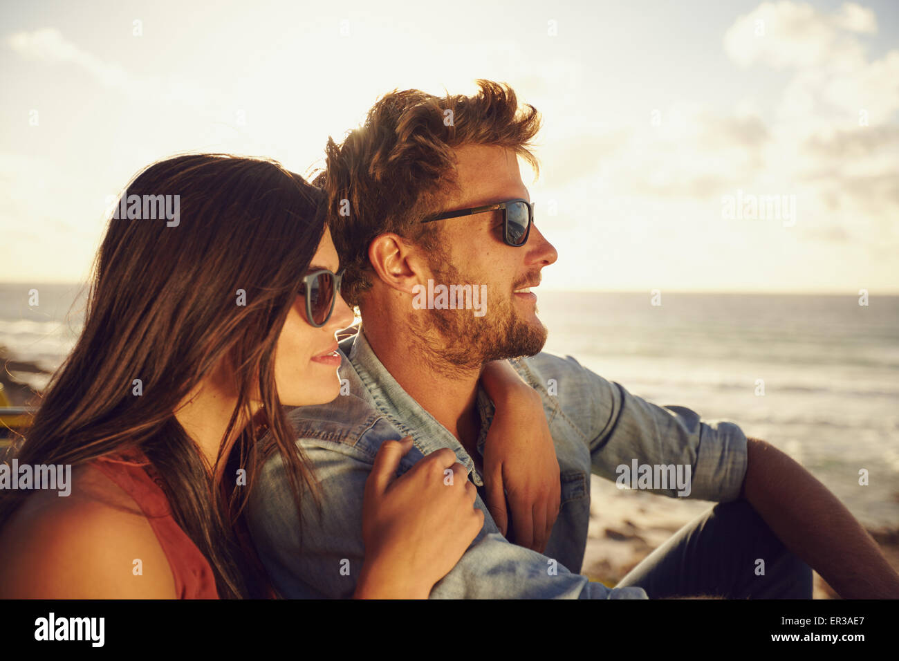 Belle jeune couple ensemble à l'extérieur sur une journée d'été. Caucasian couple appréciant la vue sur la plage, les deux portant des lunettes de soleil. Banque D'Images