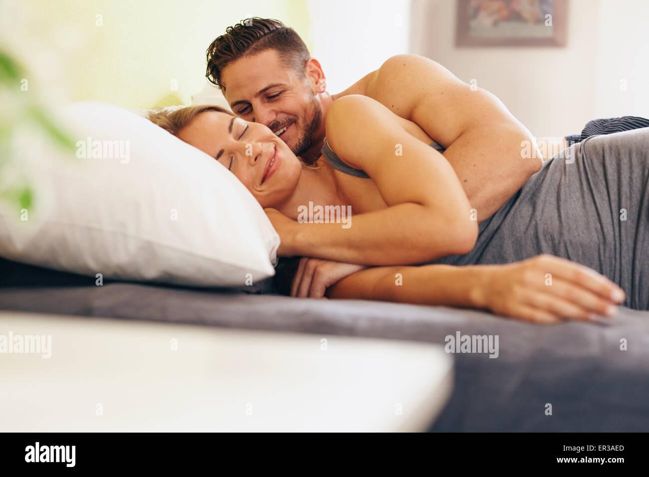 Jeune couple amoureux allongés sur le même lit dans la chambre à coucher.  Heureux l'homme et la femme se réveiller le matin Photo Stock - Alamy