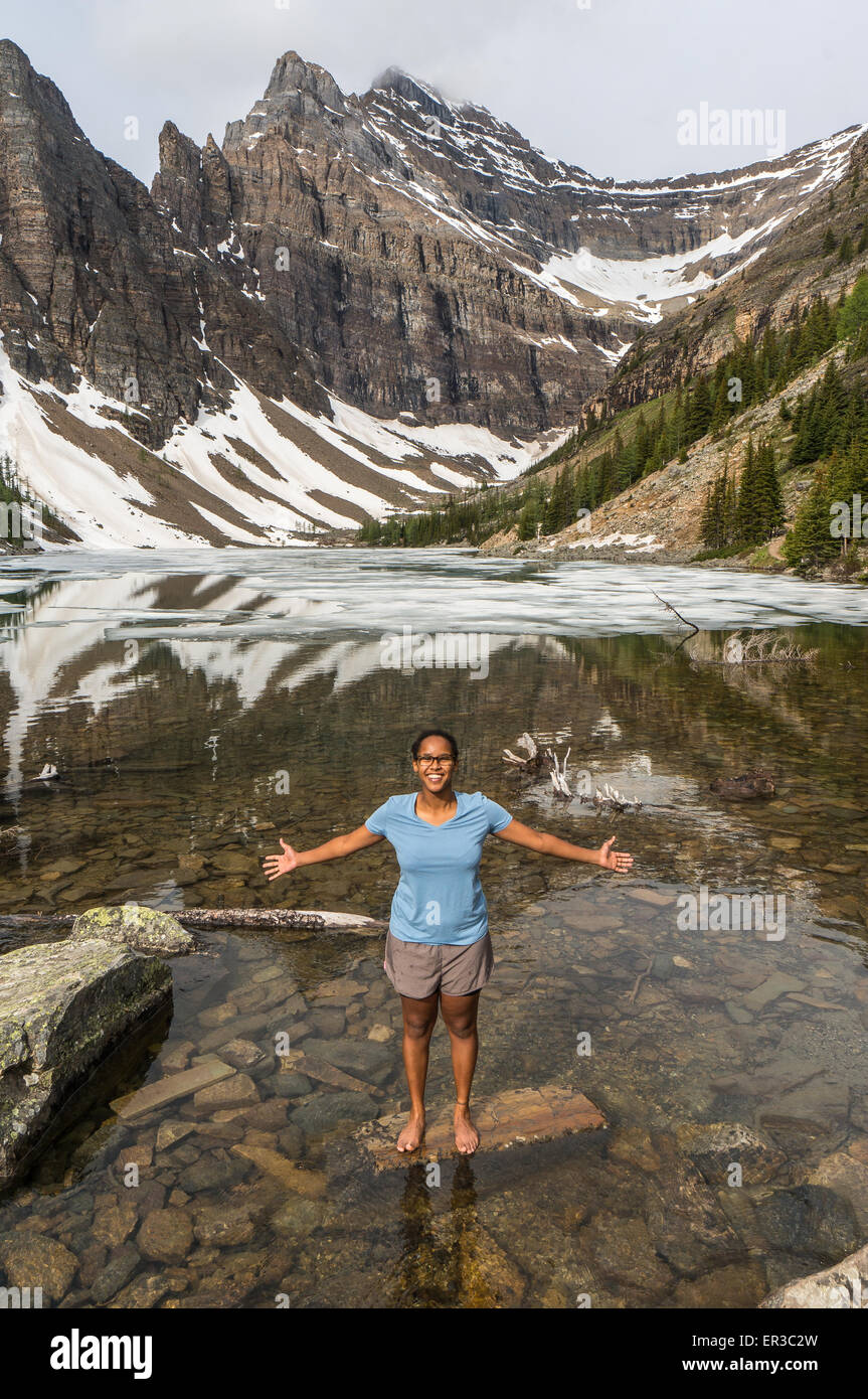 Fille debout avec les bras tendus, le lac Agnes, Banff National Park, Alberta, Canada Banque D'Images