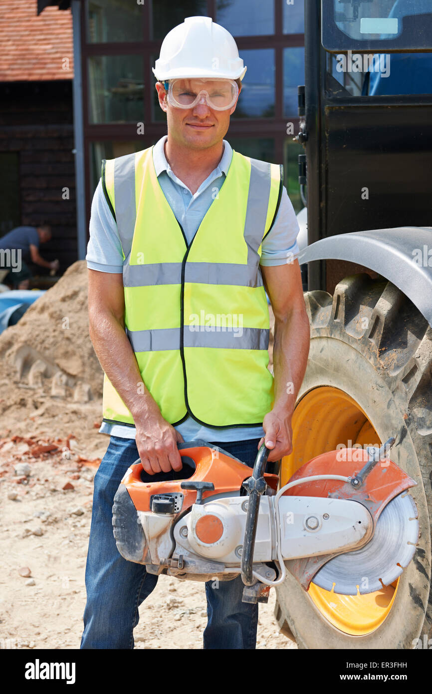 Construction Worker Holding sur le site scie circulaire Banque D'Images