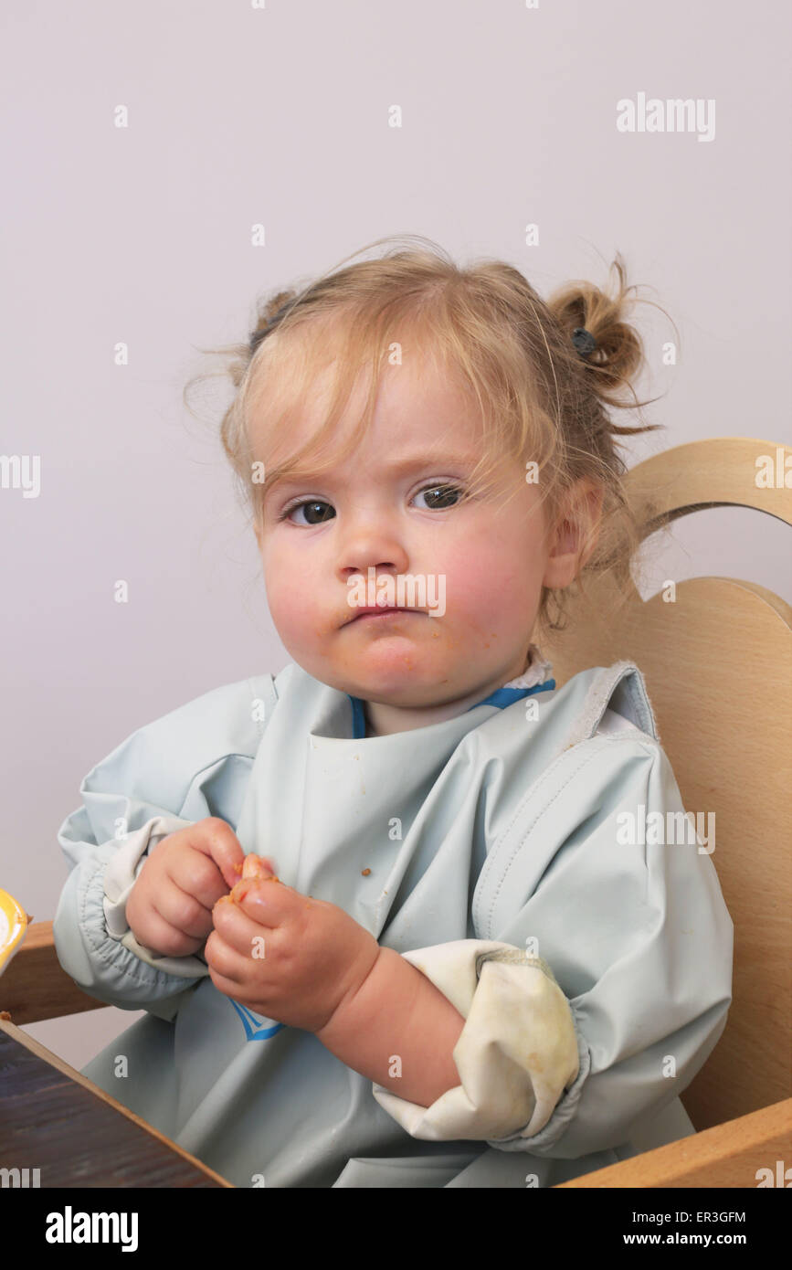 Baby Girl sitting in high chair, portrait Banque D'Images
