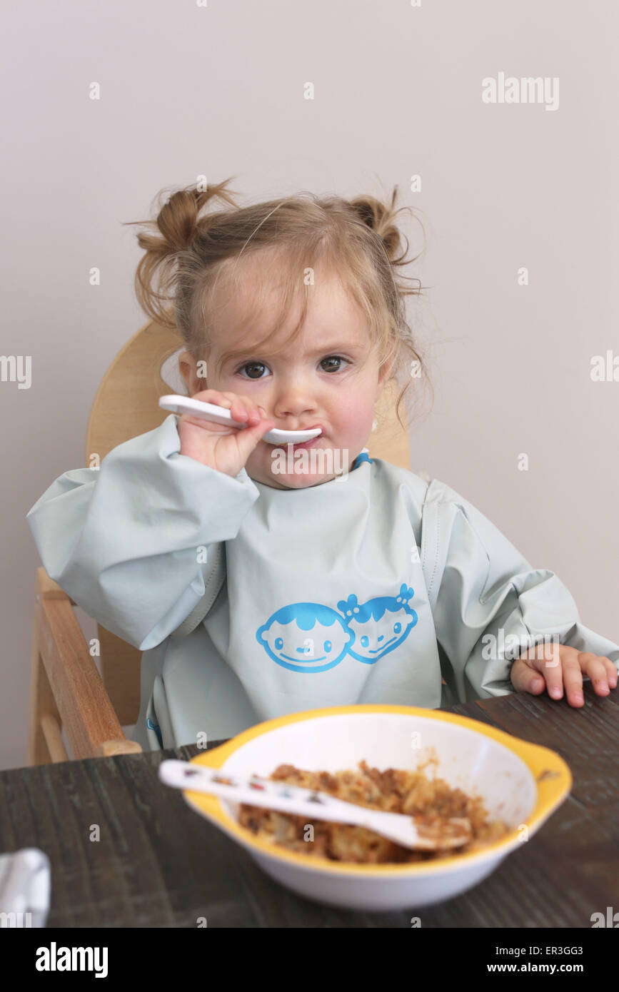 Baby Girl eating with spoon, portrait Banque D'Images