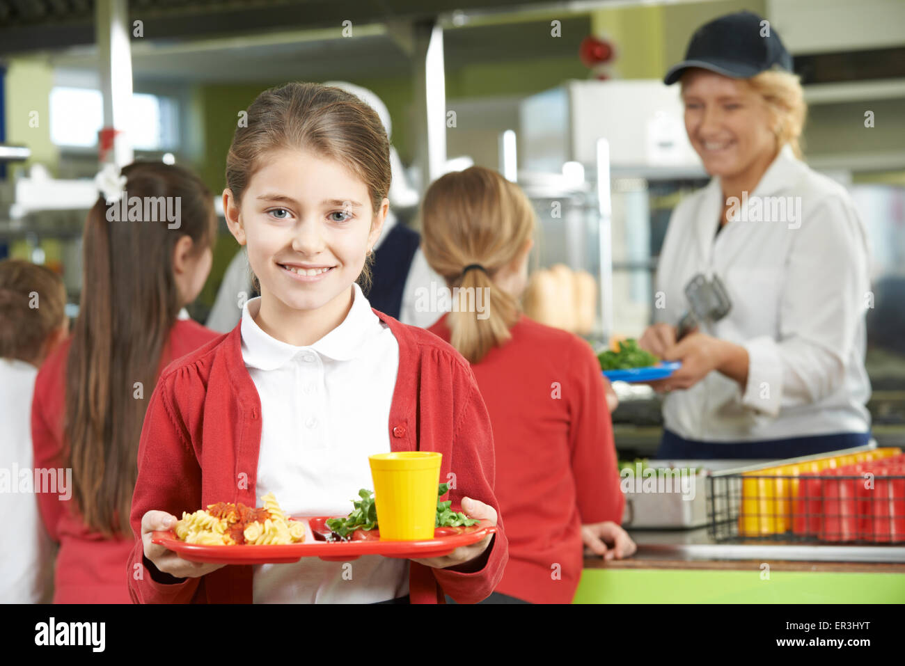 Élève de sexe féminin avec déjeuner sain dans la cafétéria de l'école Banque D'Images