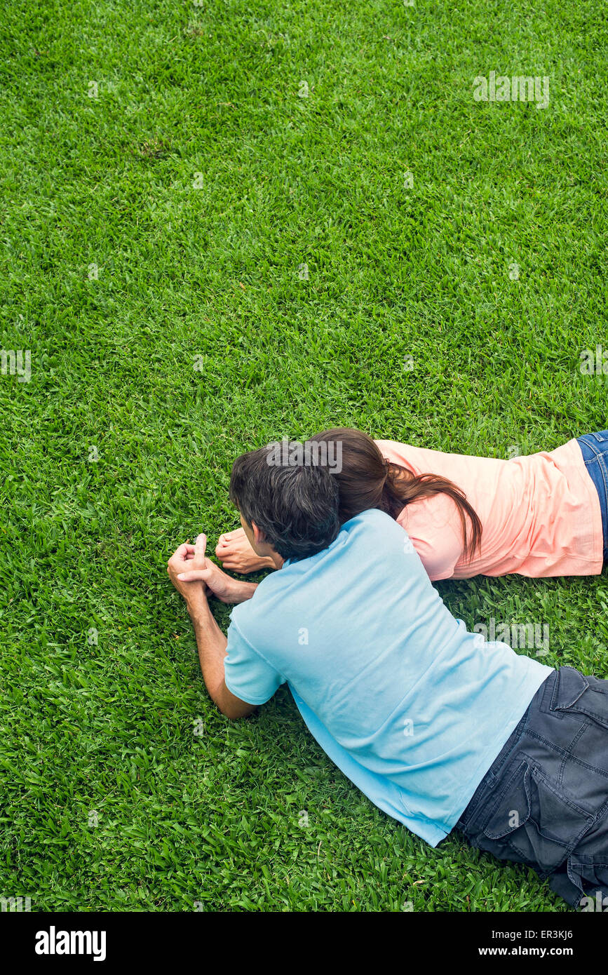 Couple lying together on grass Banque D'Images