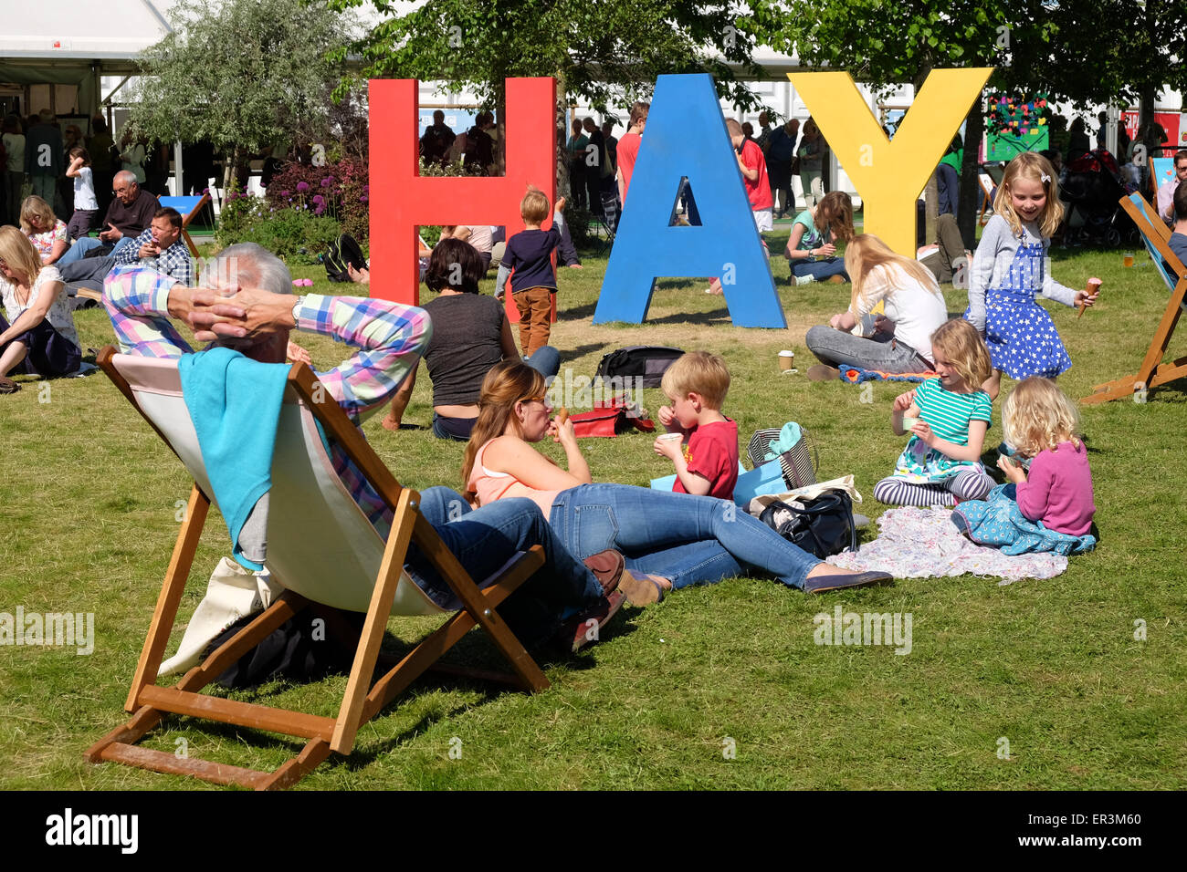 Hay Festival, Powys, Wales - Hay 2015 - demi terme amusant pour les enfants au Hay Festival qu'ils courent autour de la pelouse et jouer sur le gigantesque HAY signe. Le festival littéraire a beaucoup de sessions et les événements par les auteurs de livres pour enfants pour les jeunes lecteurs à y participer. Banque D'Images