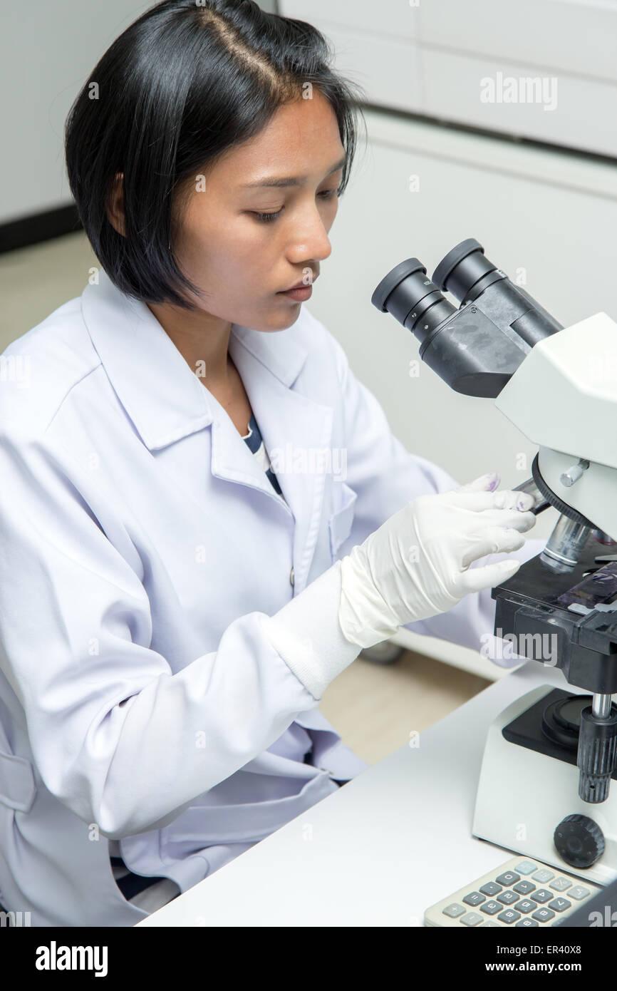 Femme travaillant dans un laboratoire avec microscope Banque D'Images
