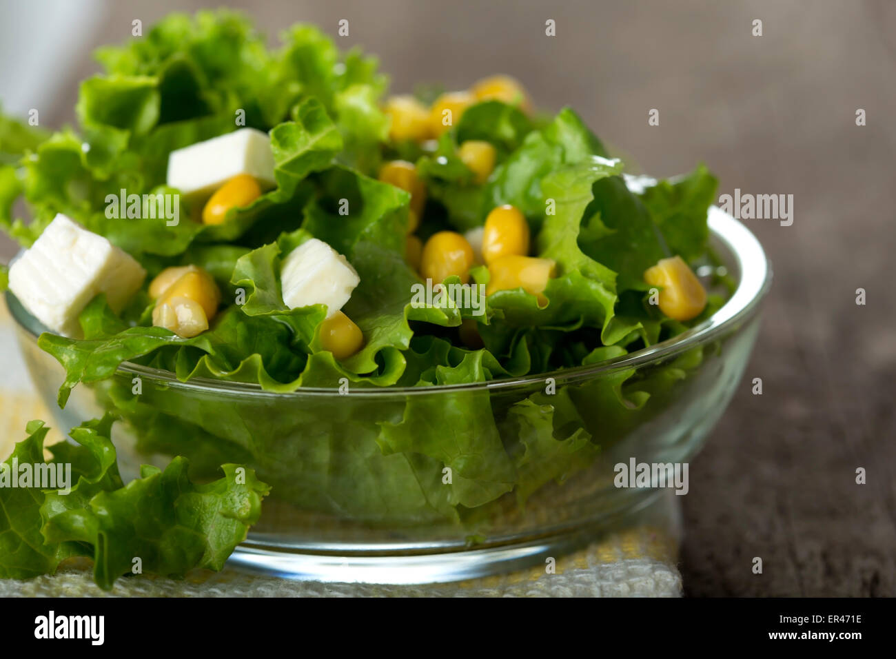 Salade fraîche avec le maïs et le fromage dans un bol sur fond de bois Banque D'Images