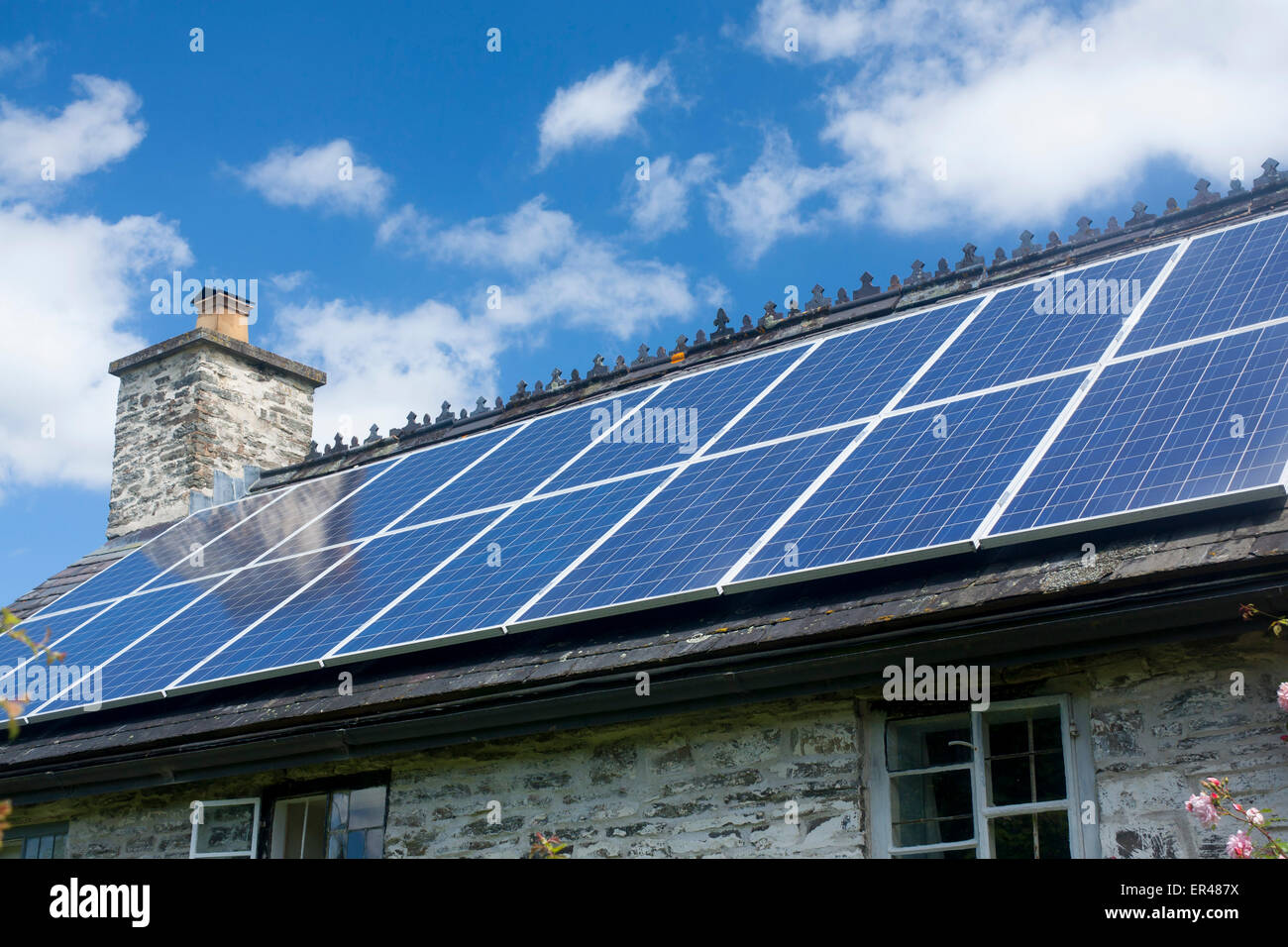 Des panneaux solaires sur toit de maison en pierre traditionnel gallois Powys Pays de Galles UK Banque D'Images