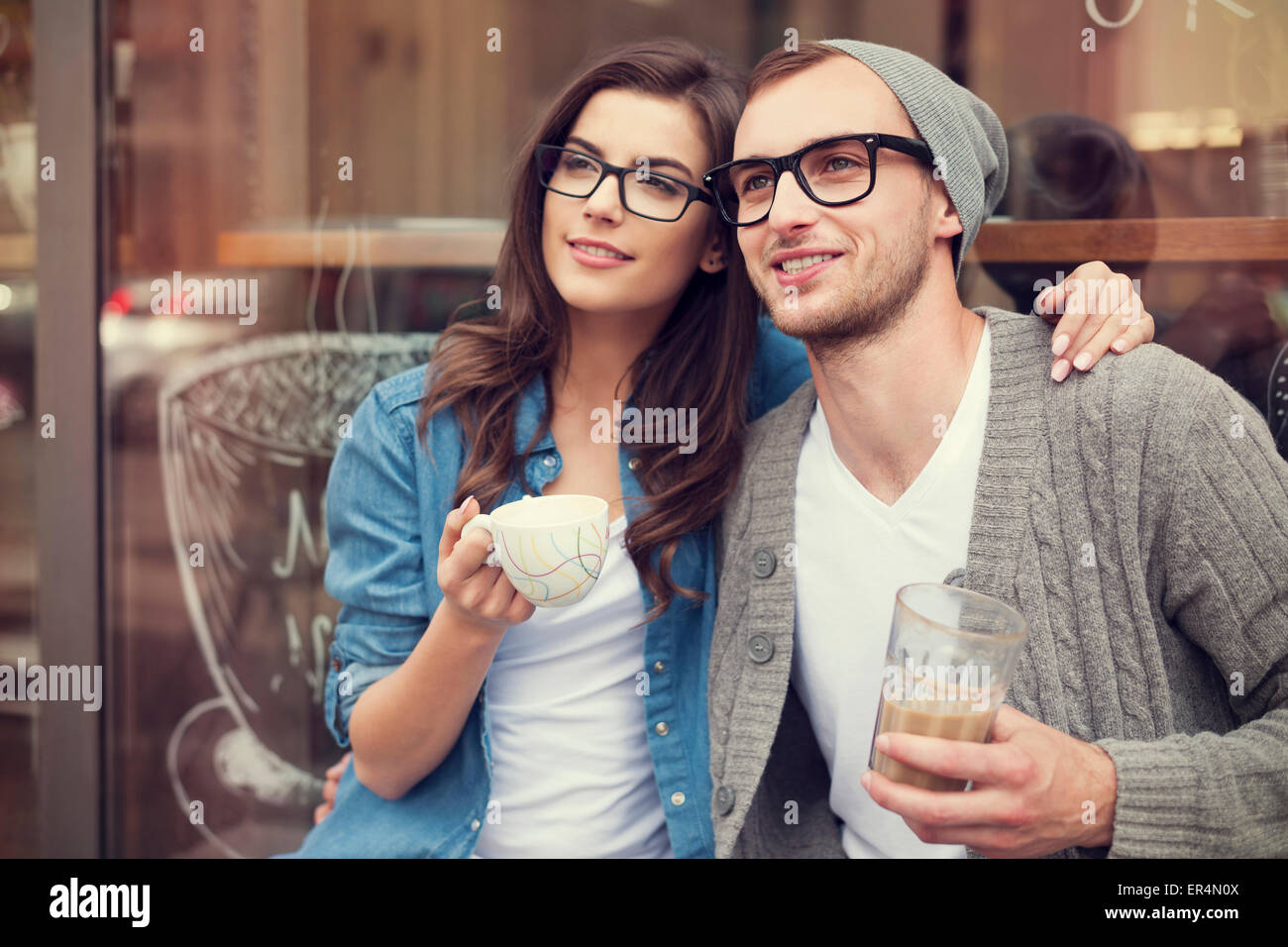 Mode jeune couple drinking coffee à l'extérieur du café. Cracovie, Pologne Banque D'Images