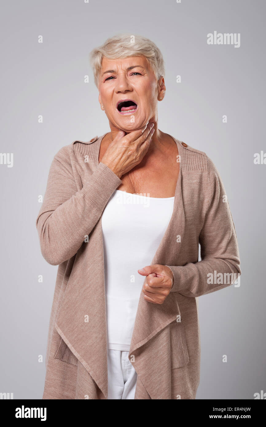 Dame plus âgée avec un mal de gorge Banque D'Images