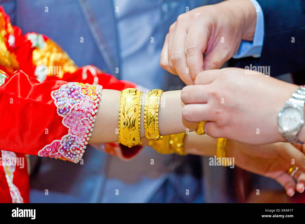 Parents âgés présentant le bracelet en or comme une bénédiction de mariage en chinois Banque D'Images