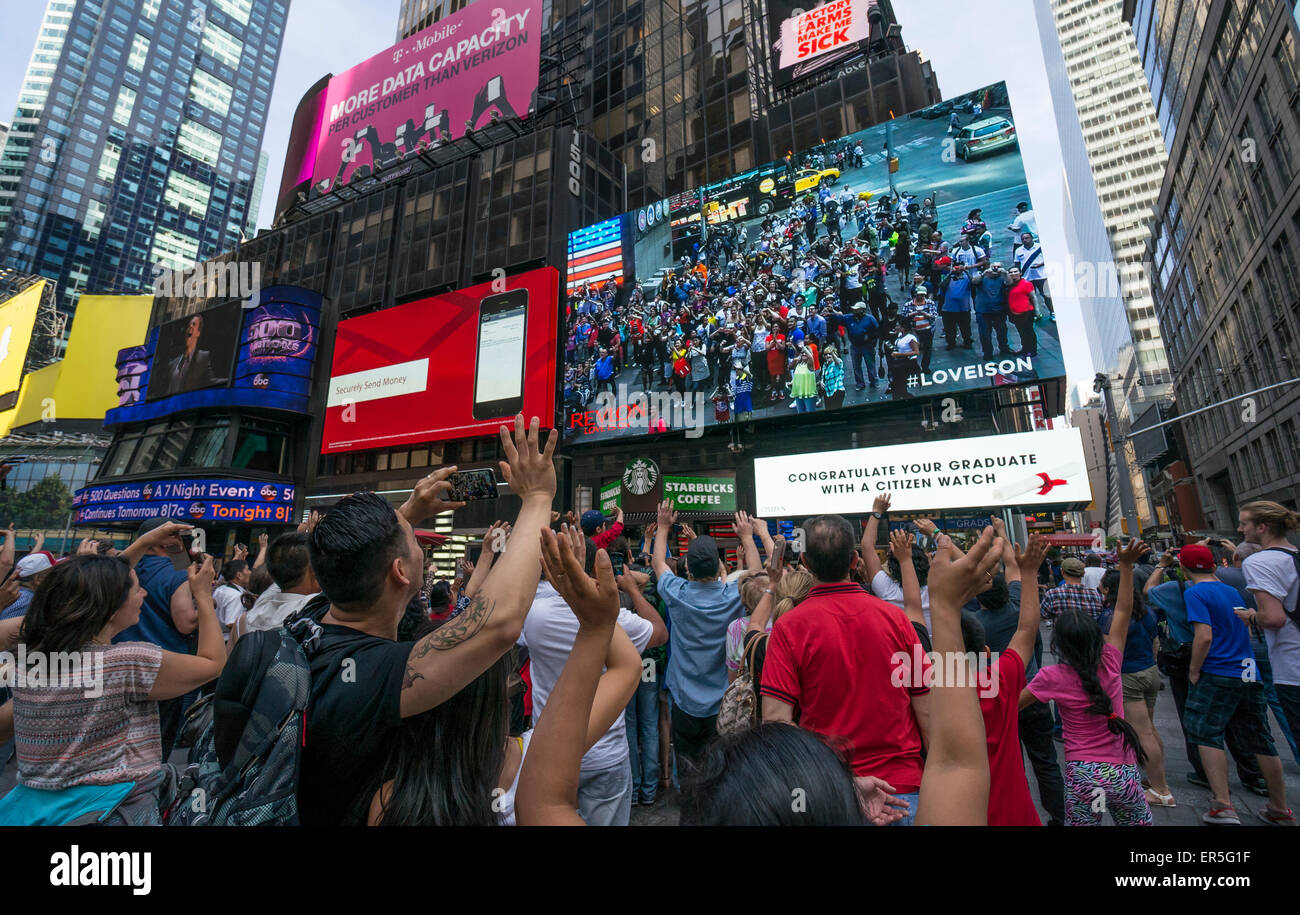 Les touristes à Times Square New York City regarder eux-mêmes sur un écran LED géant Banque D'Images