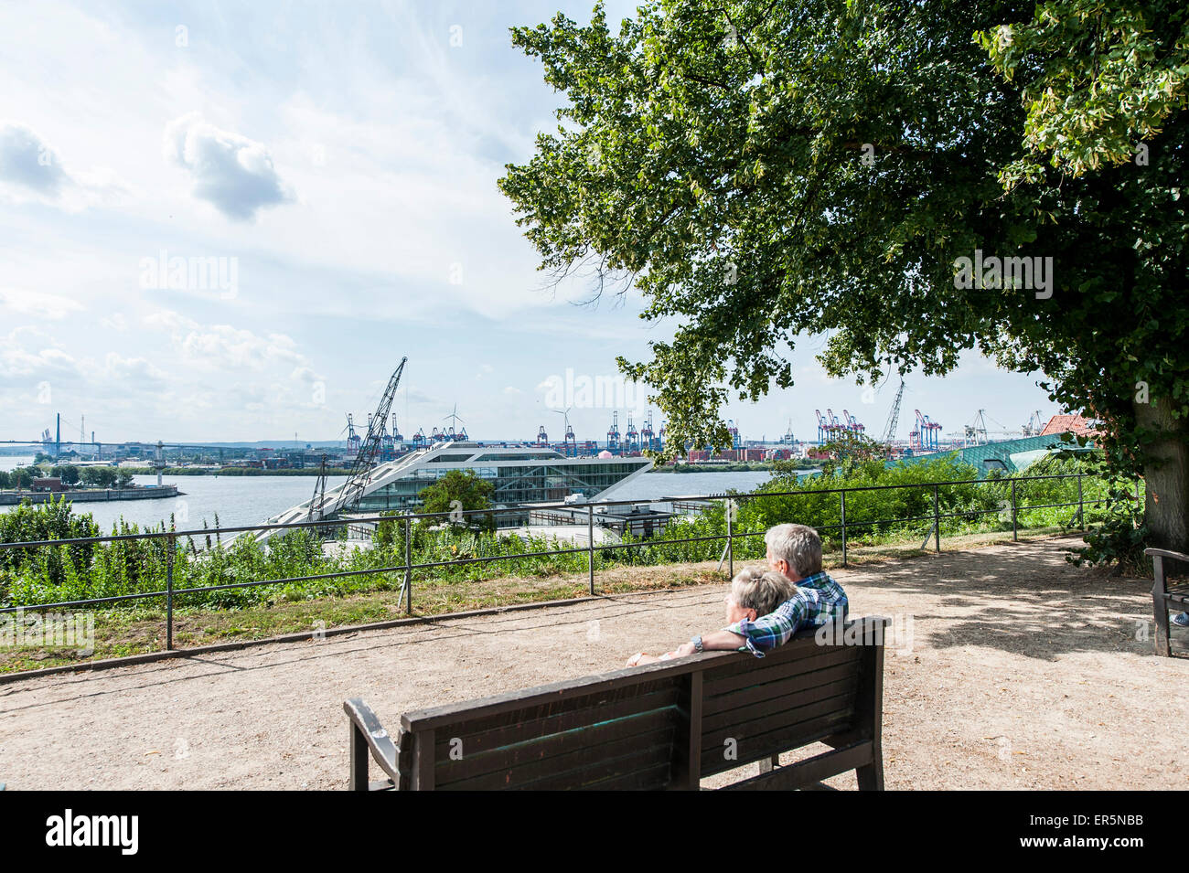 Couple assis sur un banc sur la terrasse d'Altona, regard vers le port de Hambourg, Hambourg, Allemagne Banque D'Images