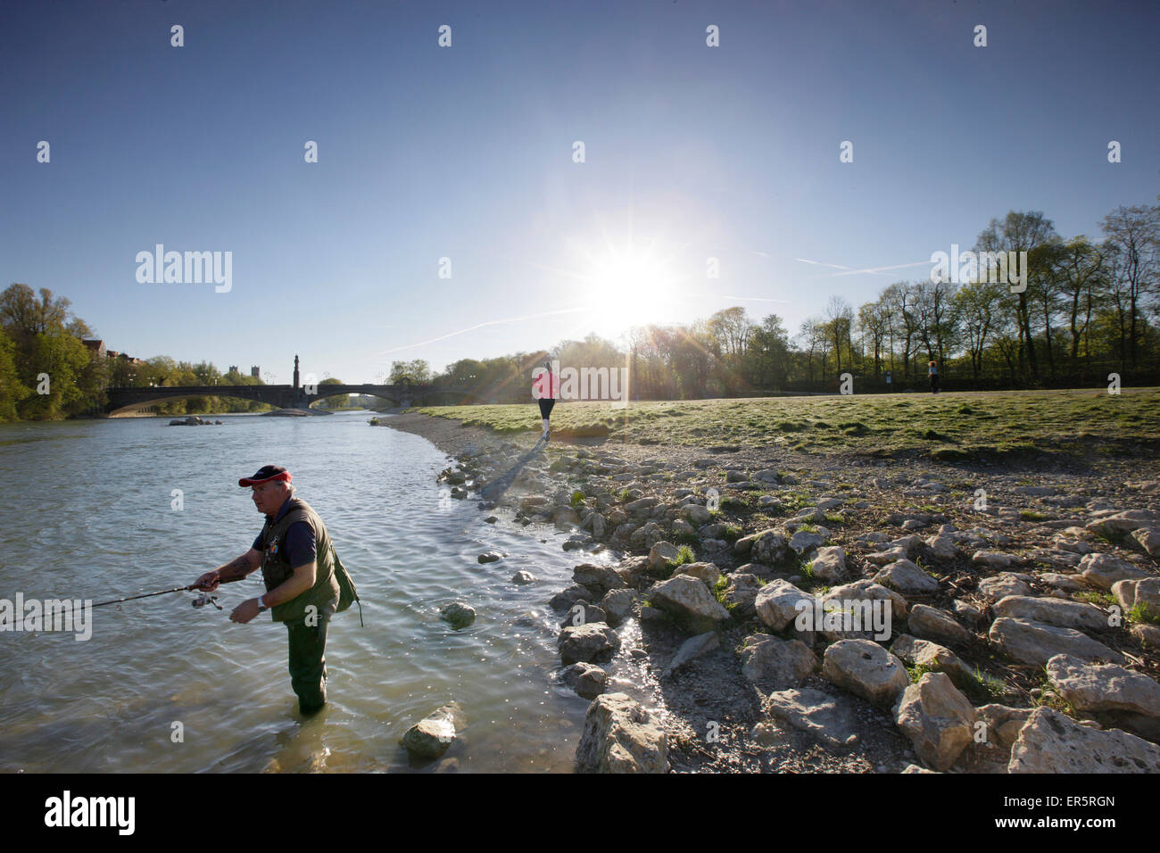 Angler et jogger à l'Isar, Wittelsbach bridge en arrière-plan, Munich, Bavière, Allemagne Banque D'Images