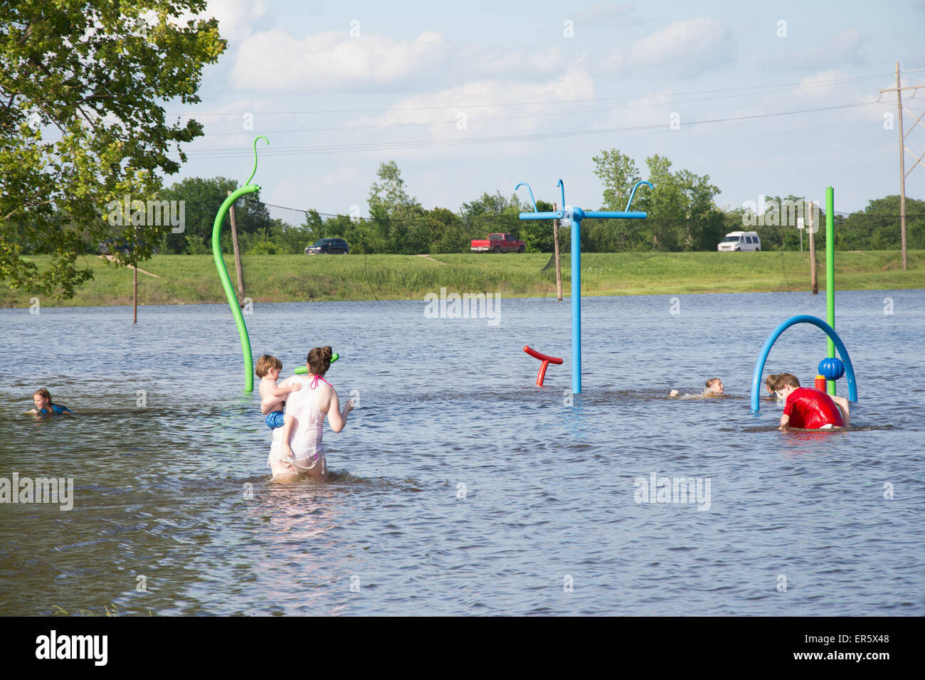 Mannford, Oklahoma, USA. 27 mai, 2015. Des enfants jouent sur l'aire de jeux publique inondée par les eaux de crue dans la région de Mannford, Oklahoma le mercredi 27 mai, 2015. New York a connu des pluies record en mai, conduisant à des inondations à grande échelle. Credit : Sari O'Neal/Alamy Live News Banque D'Images