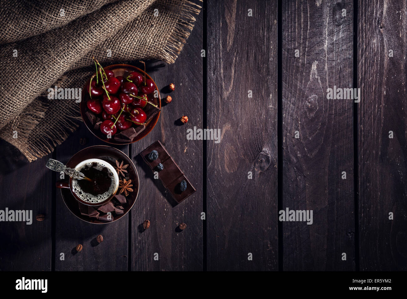 Tasse à café, chocolat noir et cerises sur la table en bois Banque D'Images