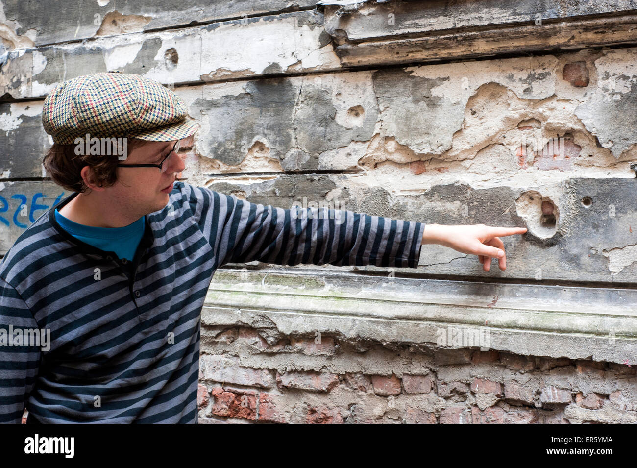 Man points à trous de balle dans un appartement occupé des édifices endommagés pendant la Seconde Guerre mondiale, Hoza street, Varsovie, Pologne, Europe Banque D'Images