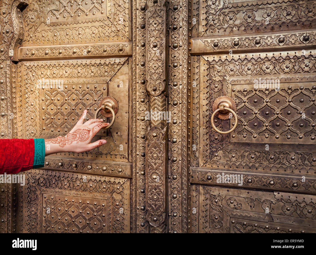 Femme part avec peinture au henné ouverture porte d'or de palais de la ville de Jaipur, Rajasthan, Inde Banque D'Images