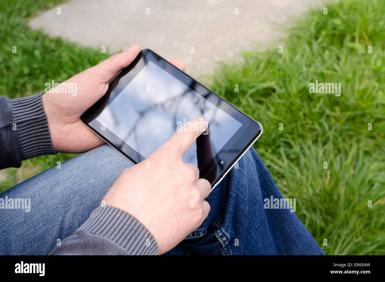 L'homme à l'aide de tablet dans le parc Banque D'Images