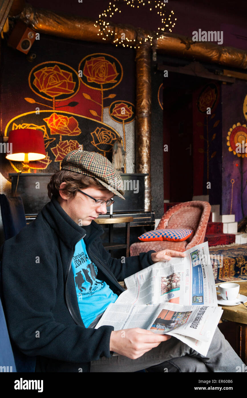 Polish man reading newspaper l'intérieur d'un bar de Bohême, W Oparach Absurdu pub, district de Prague, Varsovie, Pologne, Europe Banque D'Images