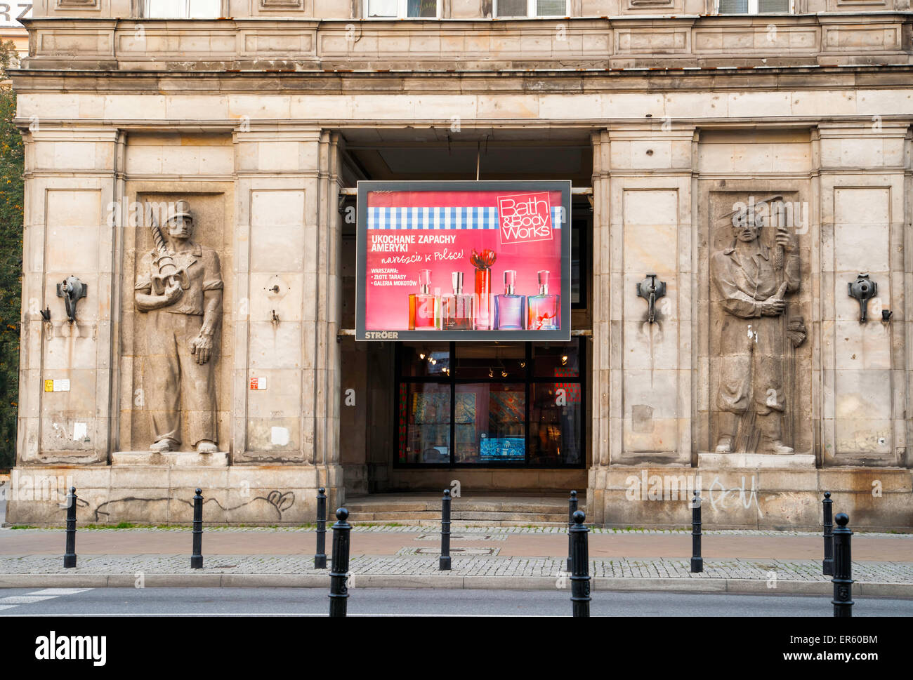 La juxtaposition d'un vieux bâtiment communiste avec les travailleurs musclés décorant la façade contemporaine et un Bain et corps sign Banque D'Images