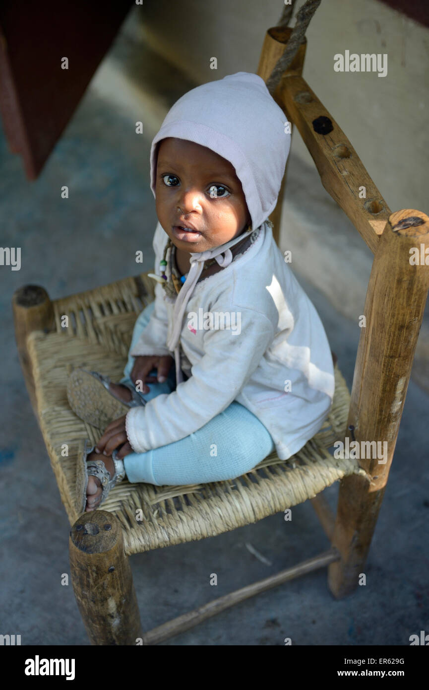 Enfant assis sur une chaise, Rivière Froide, Département de l'Ouest, Haïti Banque D'Images