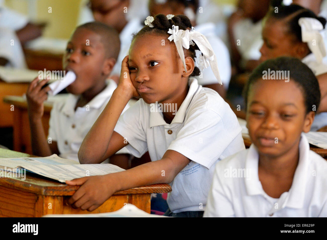 Écolière avec expression du visage maussade pendant la classe, Port-au-Prince, Haïti, Département de l'Ouest. Banque D'Images
