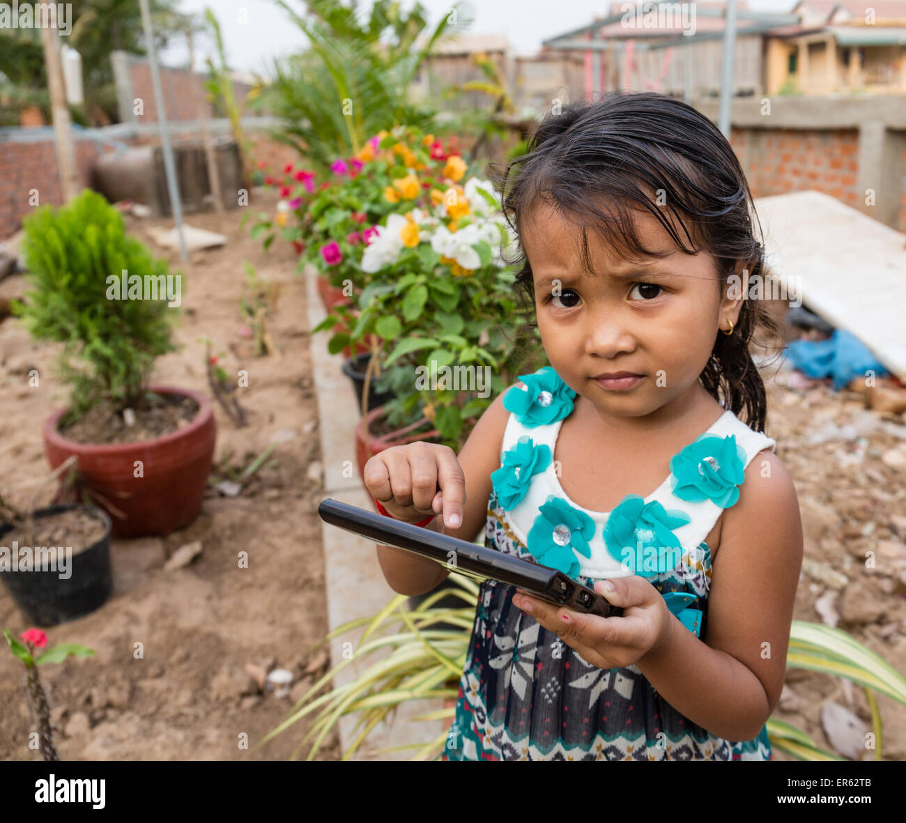 Petite fille jouant avec un ordinateur tablette, Phnom Penh, Cambodge Banque D'Images