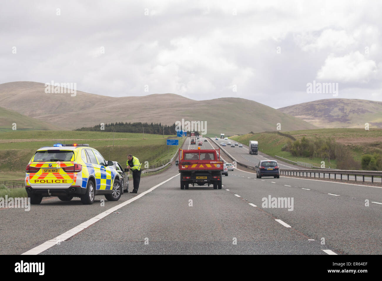 Automobiliste intercepté par le côté de l'autoroute M74 en direction sud par un agent de police dans l'auto-patrouille - Écosse, Royaume-Uni Banque D'Images