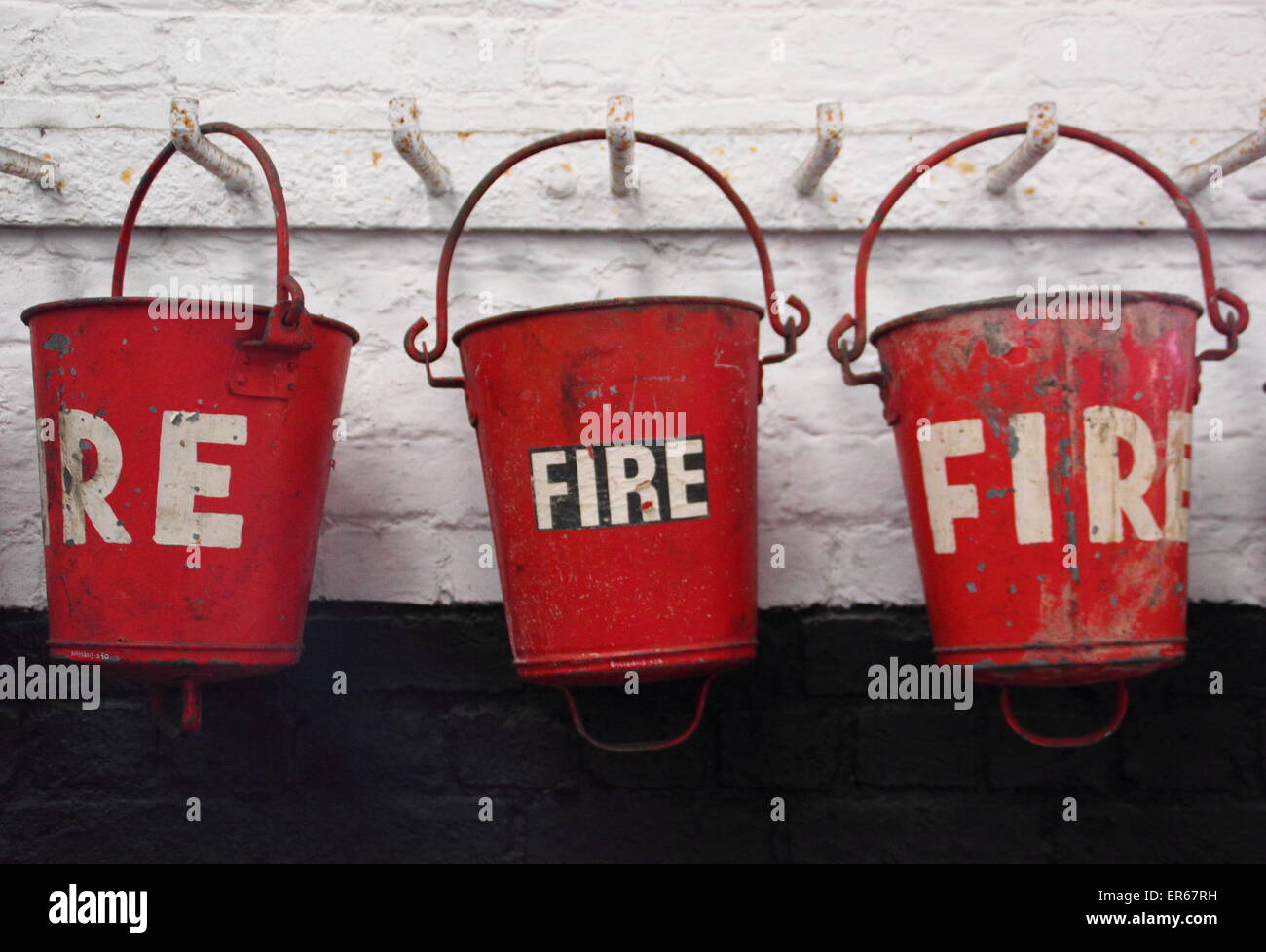 Une rangée de seaux d'incendie vintage accrocher de suite, England, UK Banque D'Images