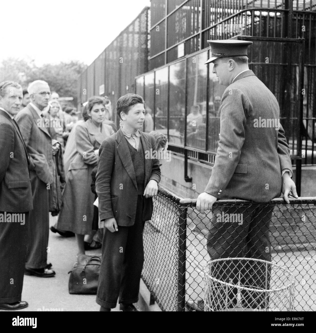 Ron Smith, Zoo Keeper, parlant avec Clifford Preece 15, qui a été témoin d'un incident avec Guy le gorille au Zoo de Londres, que l'on voit à l'extérieur de la cage du Gorille, le 18 juin 1956. Banque D'Images