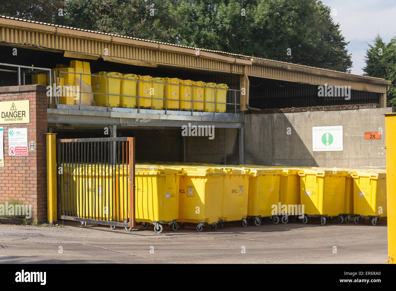 Clinique en vrac jaune vif de poubelles à côté de l'usine d'incinération des déchets à l'Hôpital Royal de Bolton, Lancashire. Banque D'Images
