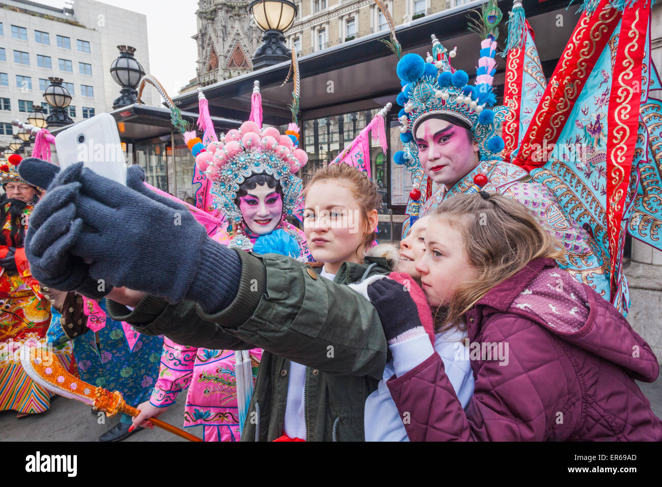 Londres, Soho, Chinatown, le Nouvel An Chinois Défilé du Festival, les filles de prendre des photos avec les participants Selfies Banque D'Images