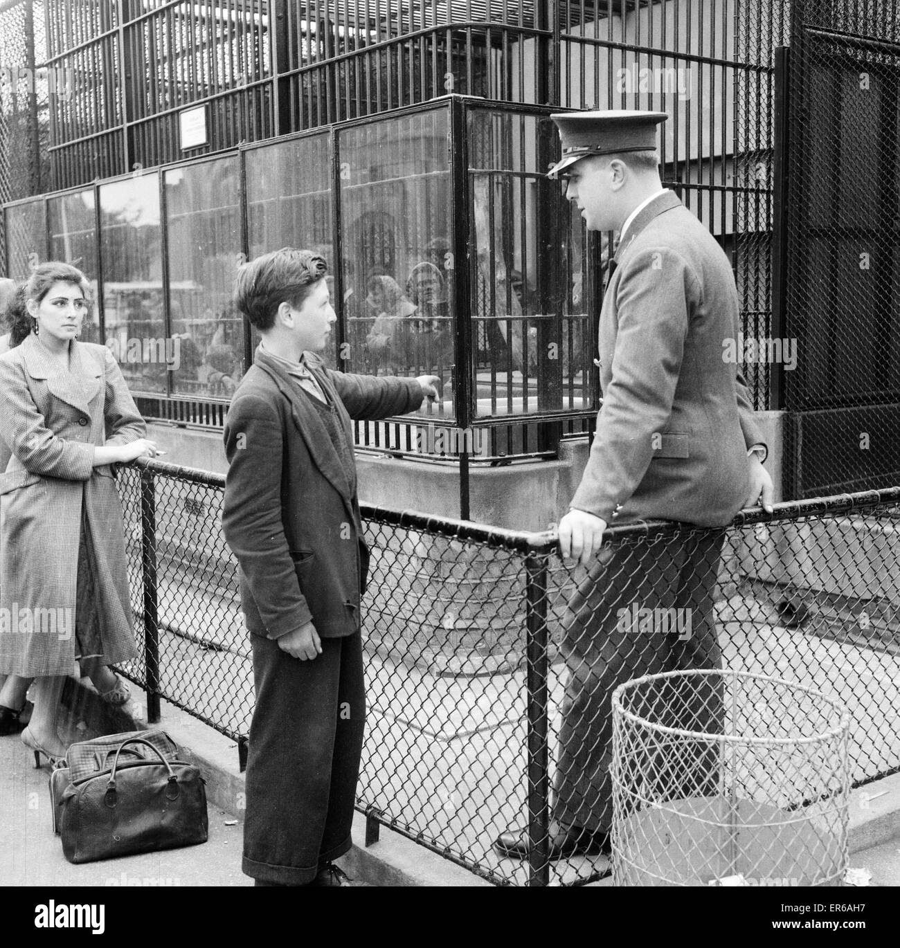 Ron Smith, Zoo Keeper, parlant avec Clifford Preece 15, qui a été témoin d'un incident avec Guy le gorille au Zoo de Londres, que l'on voit à l'extérieur de la cage du Gorille, le 18 juin 1956. Banque D'Images
