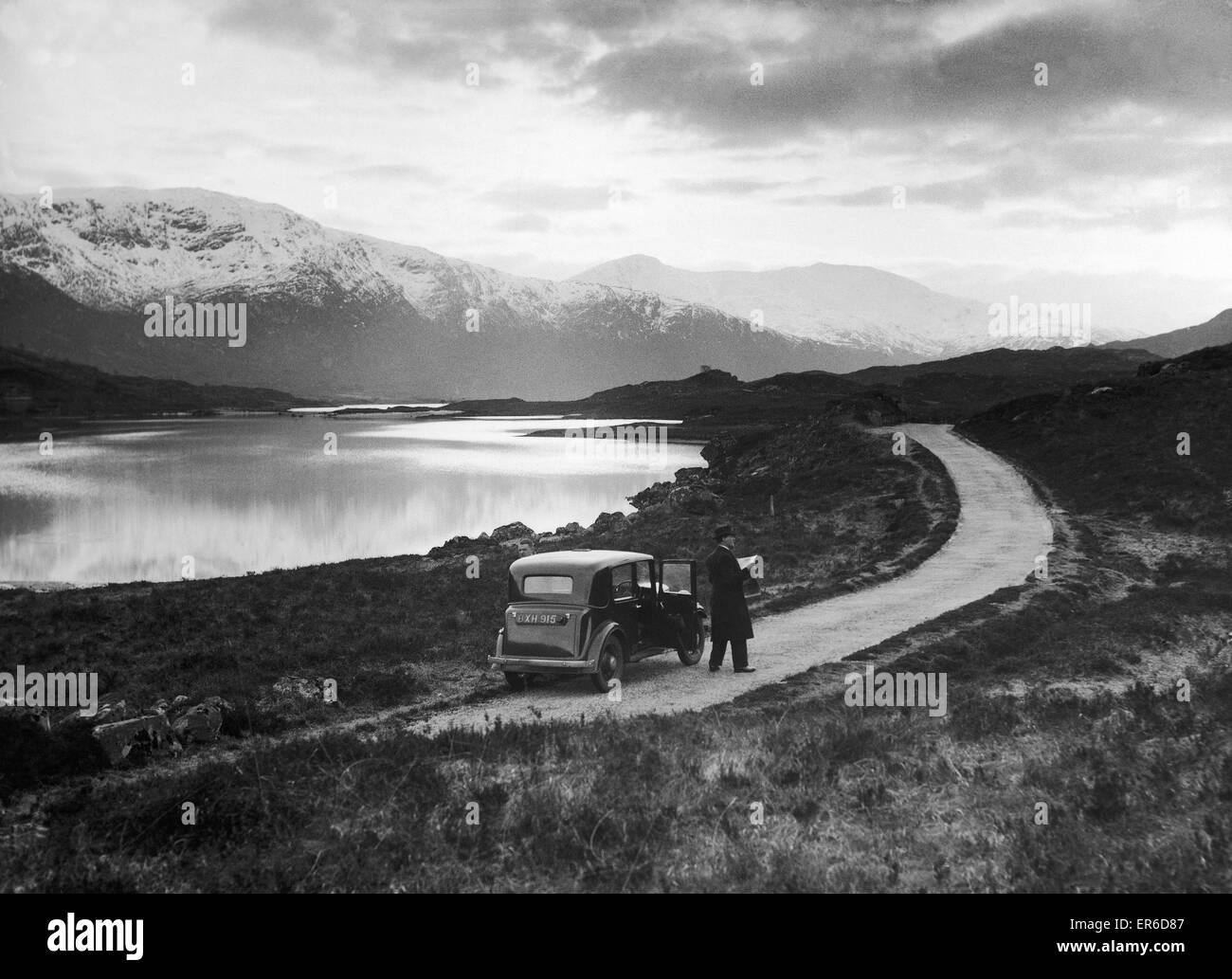 Chauffeur consulte son site tout en garé au bord du Loch Cluanie, Inverness Shire. 25 Mars 1936 Banque D'Images